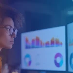 Professional wearing glasses analyzes data dashboards on two monitors; B EYE logo in the top right corner.