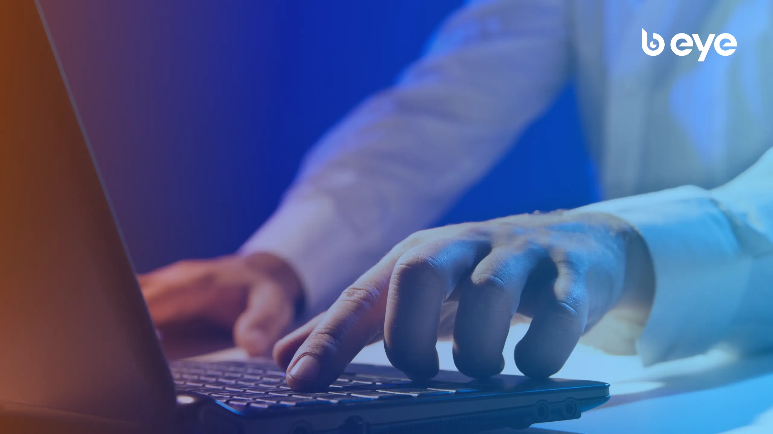 Close-up of a person typing on a laptop with a blue gradient overlay and the B EYE logo in the top-right corner.