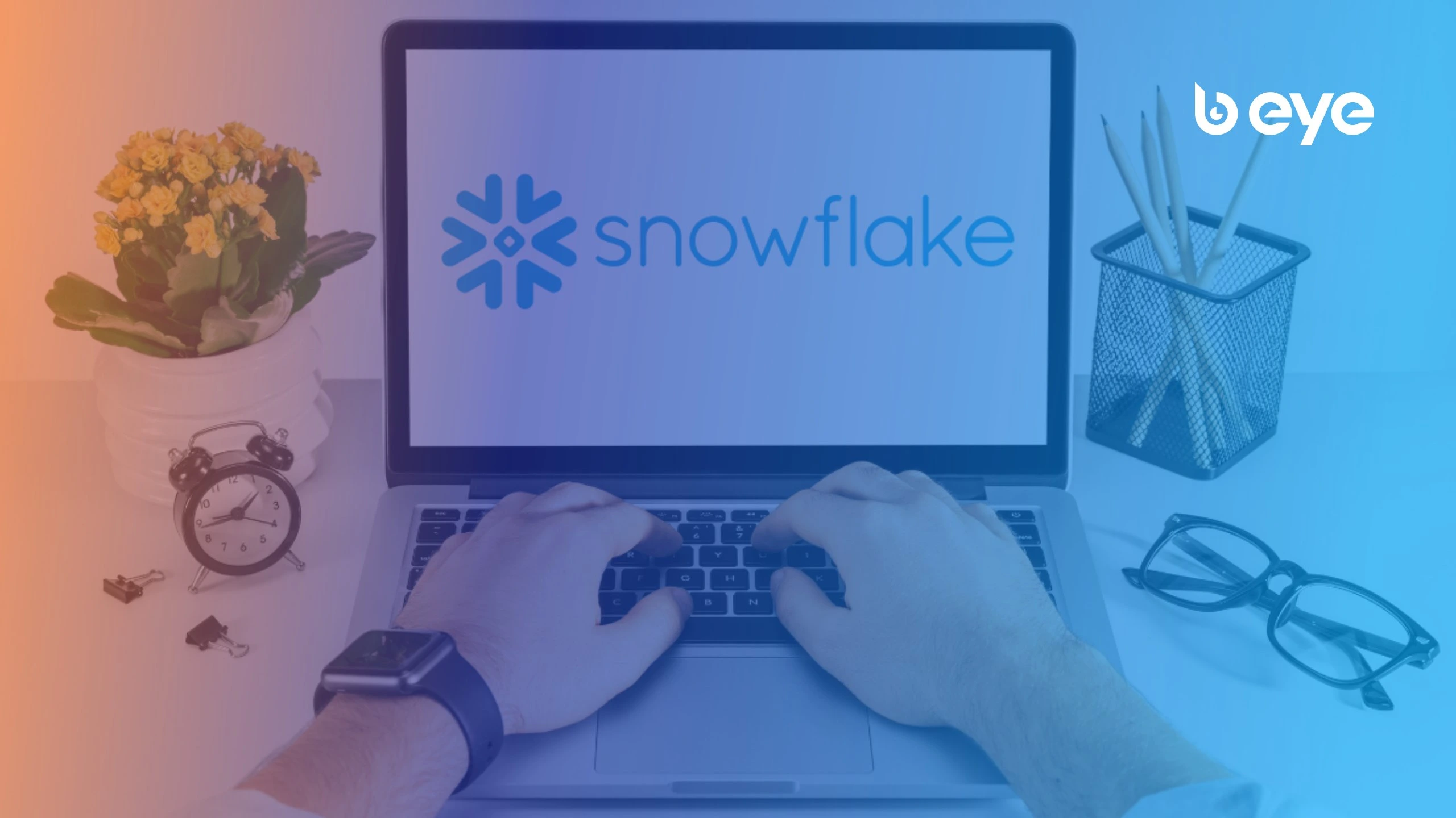 B EYE article cover image for "Distributed Deep Learning with PyTorch on Snowflake GPUs: A Hands-On Tutorial" showing a person typing on a laptop with the Snowflake logo on the screen, surrounded by a desk with a clock, flowers, glasses, and a pencil holder, overlaid with a blue and orange gradient and the B EYE logo in the top right corner.